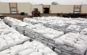 A large pile of filled sandbags neatly stacked inside a warehouse facility.