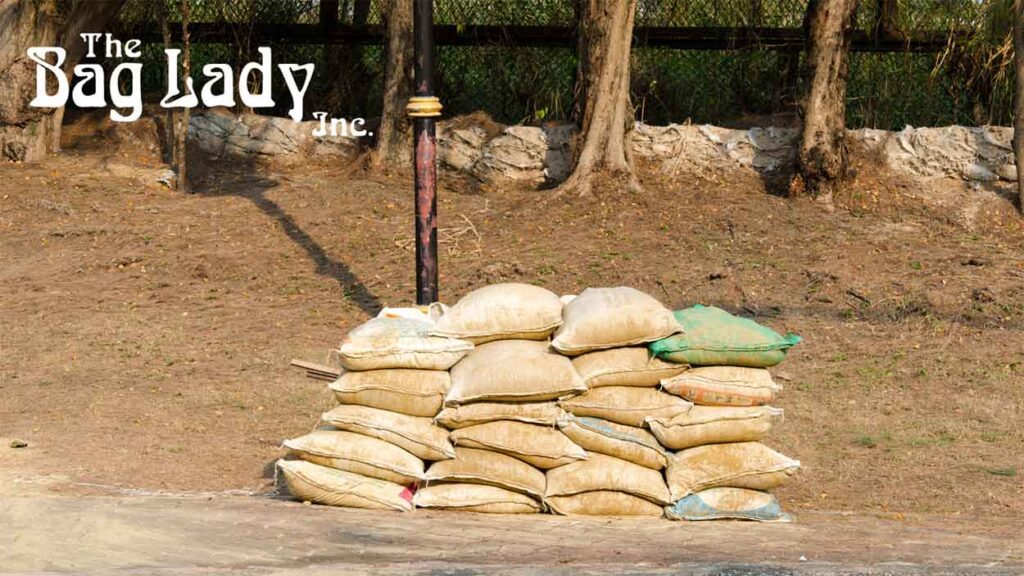Stacked sandbags used for flood control in a waterlogged location.